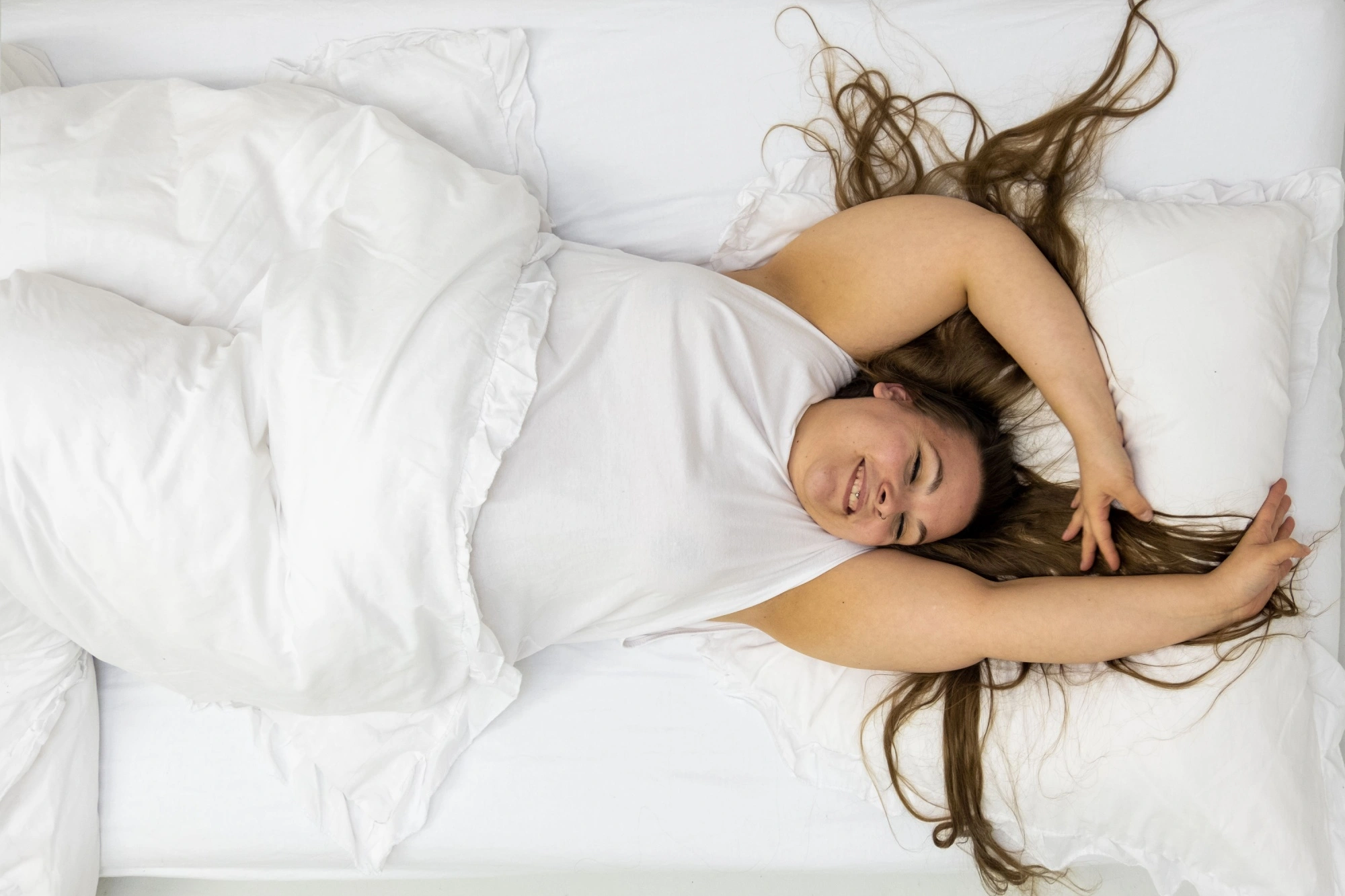 heavy woman happily laying on her new mattress