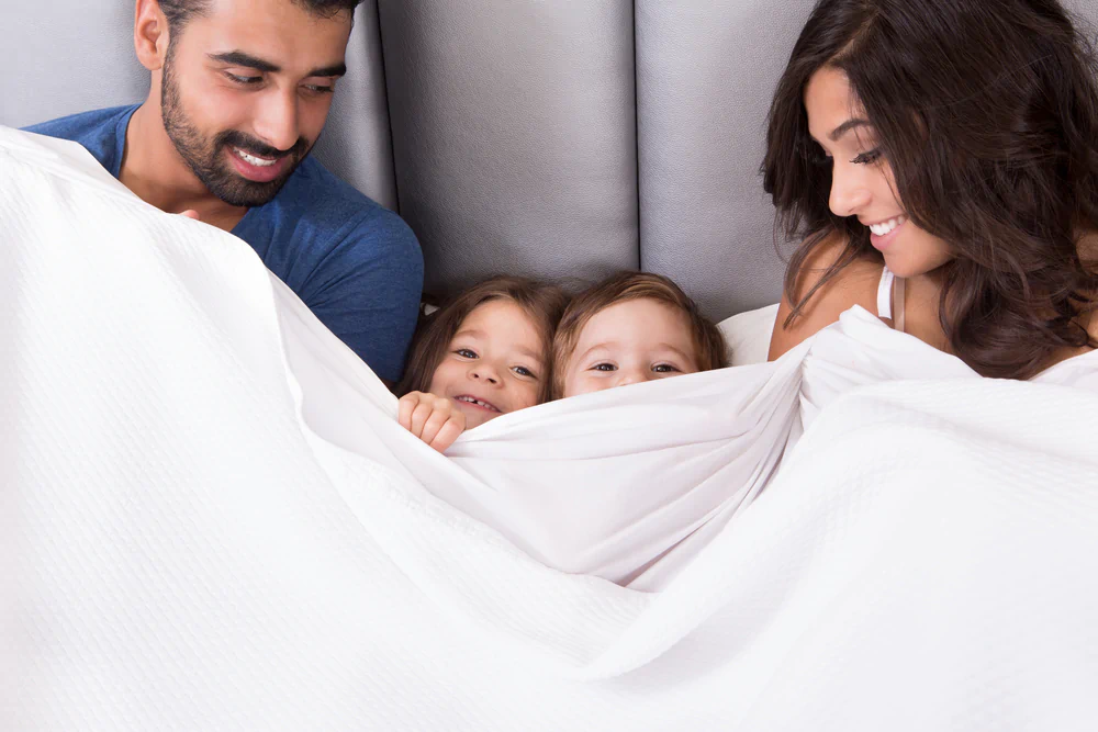 Parents and two children cuddling in bed