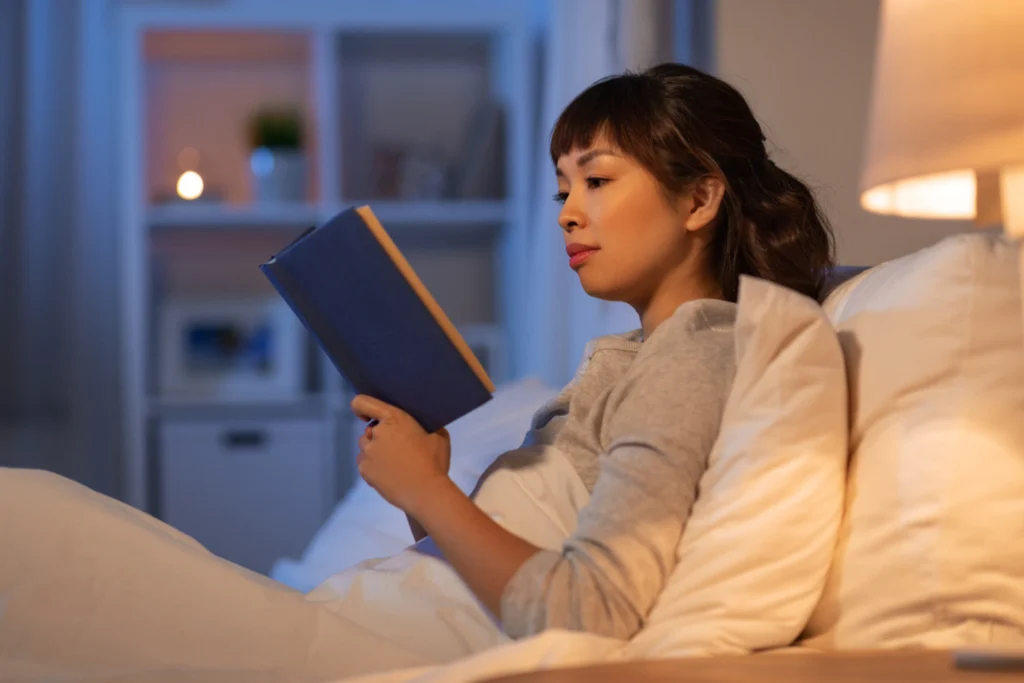 Woman sitting up in bed reading